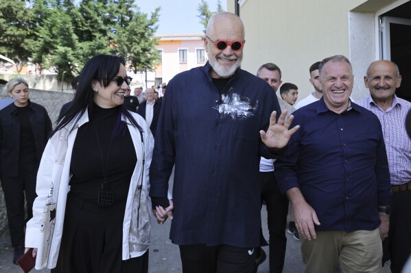 Albania's ruling Socialist party leader Edi Rama, center, and his wife Linda, left, leave a voting station during a general election where Rama is seeking a fourth term as Albania's prime minister in Tirana, Albania Sunday, May 11, 2025. (AP Photo/Vlasov Sulaj)